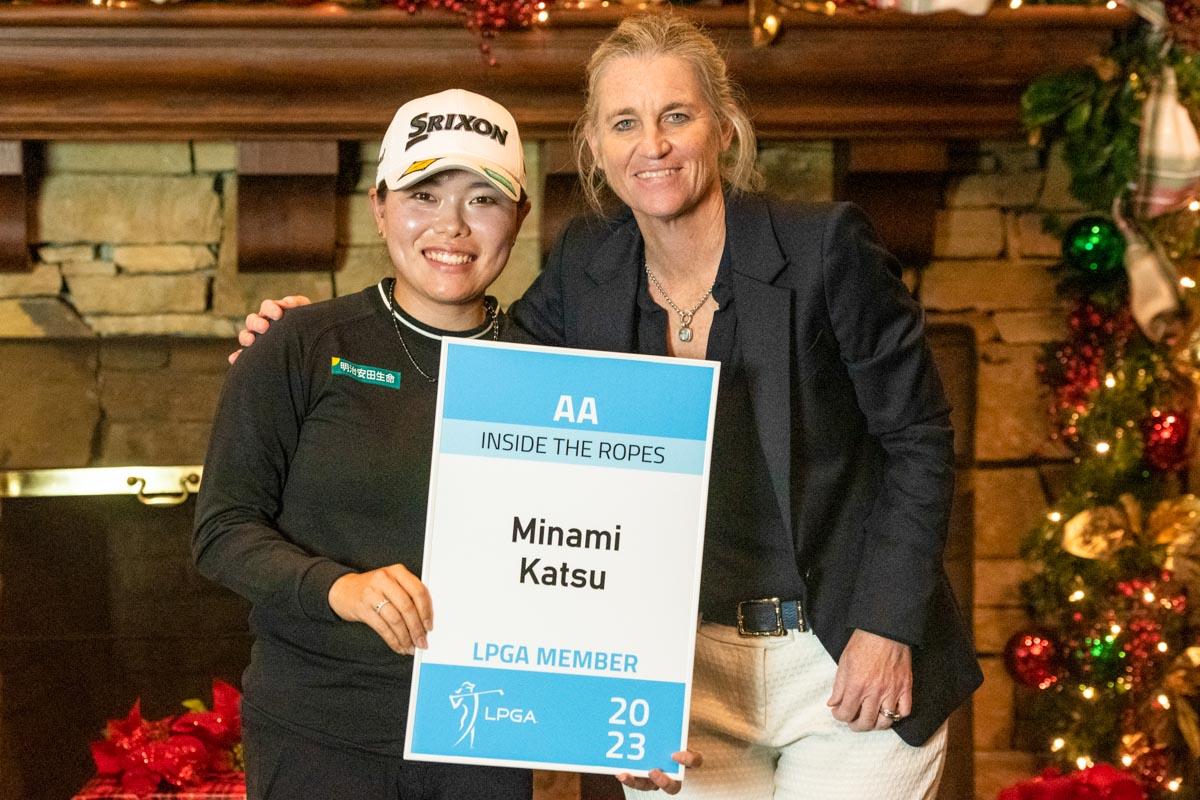 米LPGAツアーコミッショナーのモリー・サマーン氏からツアーメンバーの目録を手渡され、笑顔を見せる勝みなみ　写真：Getty Images