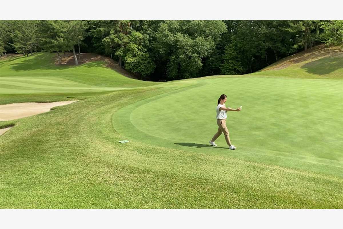 1秒に1回“地点登録”を行なう器械を持ち、グリーンのカラー部分を一周歩いてトレース　写真：朝日ゴルフ提供