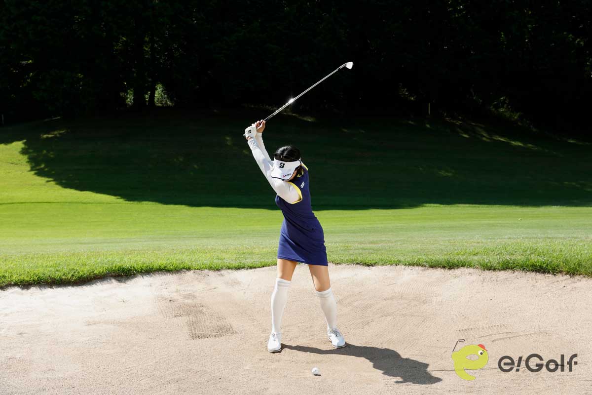 クラブを短く持ち、足を砂に埋めずにアドレス。いつもよりボール一個ぶん右足寄りにボールをセットして、いつもどおりのスイングする