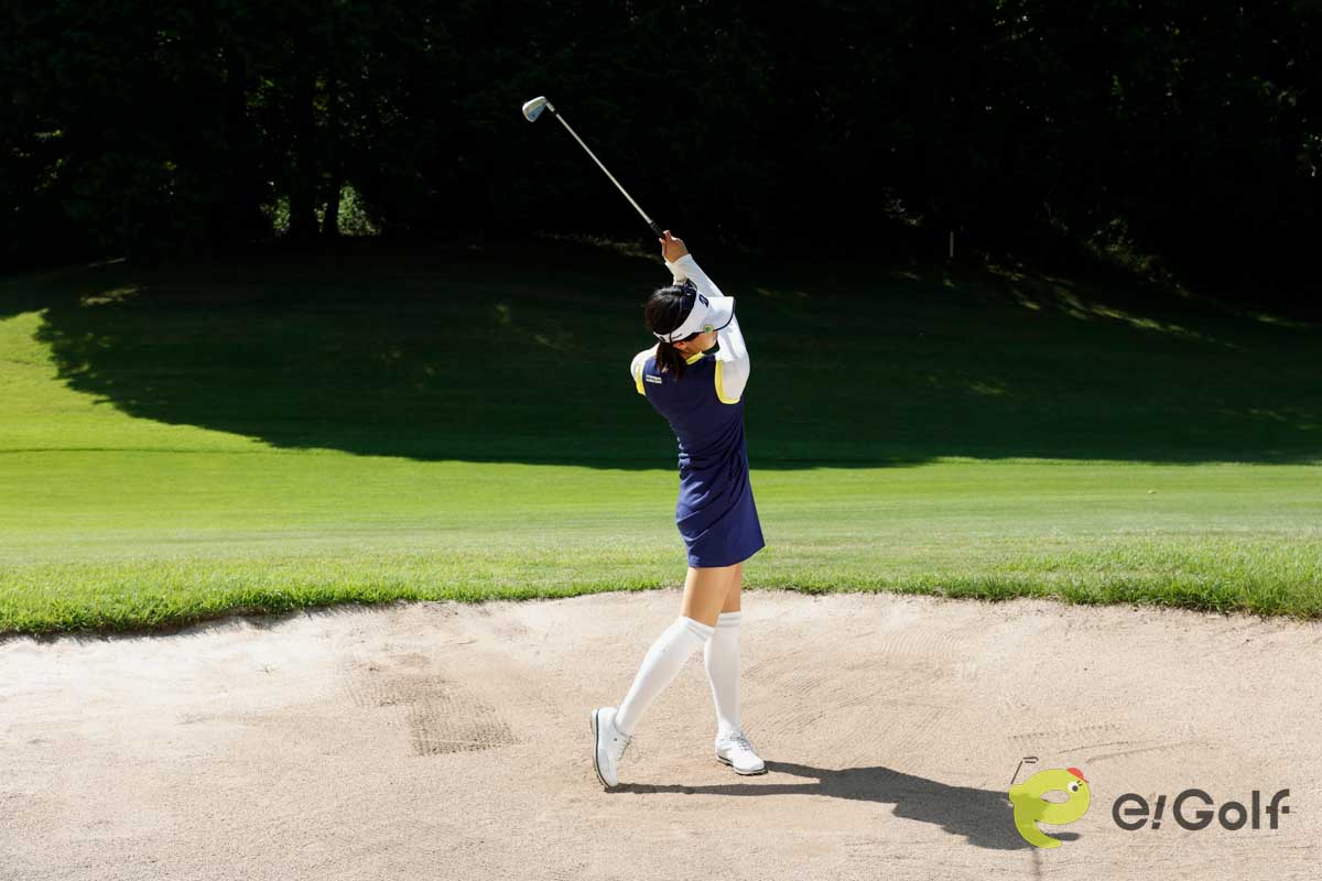 クラブを短く持ち、足を砂に埋めずにアドレス。いつもよりボール一個ぶん右足寄りにボールをセットして、いつもどおりのスイングする