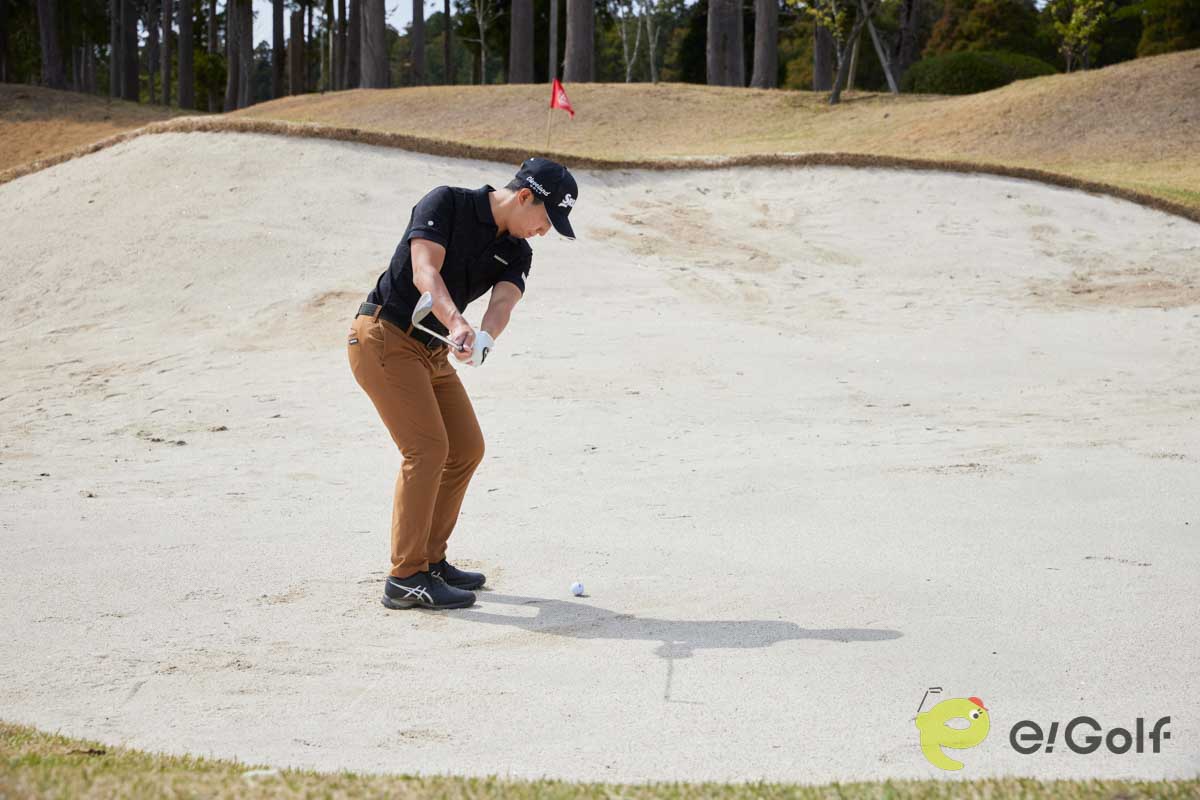 腰と手元を落として構え、コックを使ってスイングするのは危険。ヘッドが鋭角に動いて砂に弾かれてしまう。硬い砂のバンカーは、20～30ヤードのアプローチを打つ感覚で臨む