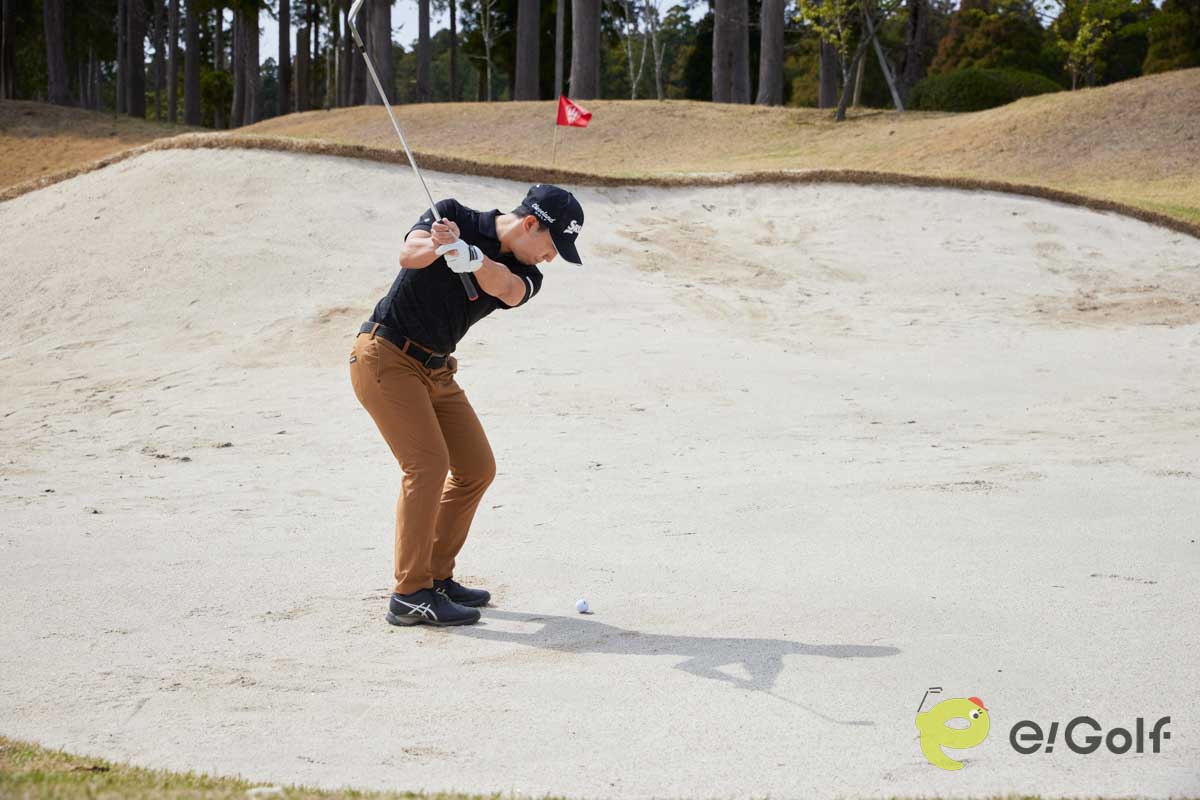 腰と手元を落として構え、コックを使ってスイングするのは危険。ヘッドが鋭角に動いて砂に弾かれてしまう。硬い砂のバンカーは、20～30ヤードのアプローチを打つ感覚で臨む