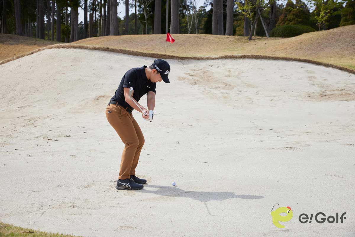 腰と手元を落として構え、コックを使ってスイングするのは危険。ヘッドが鋭角に動いて砂に弾かれてしまう。硬い砂のバンカーは、20～30ヤードのアプローチを打つ感覚で臨む