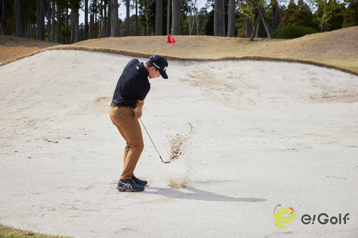 腰と手元を落として構え、コックを使ってスイングするのは危険。ヘッドが鋭角に動いて砂に弾かれてしまう。硬い砂のバンカーは、20～30ヤードのアプローチを打つ感覚で臨む