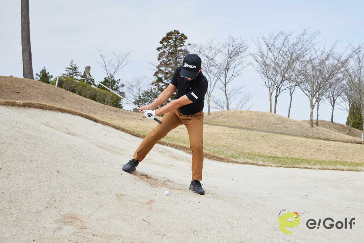 フェースを1時の向きに開き、真ん中よりもやや左足寄りにボールをセット。左足に重心を乗せてクローズスタンスで構えよう。右肩に担ぐようにバックスイングして、低いフォローを出せばOK。傾斜なりにヘッドが動き、フワっと球を上げることができる