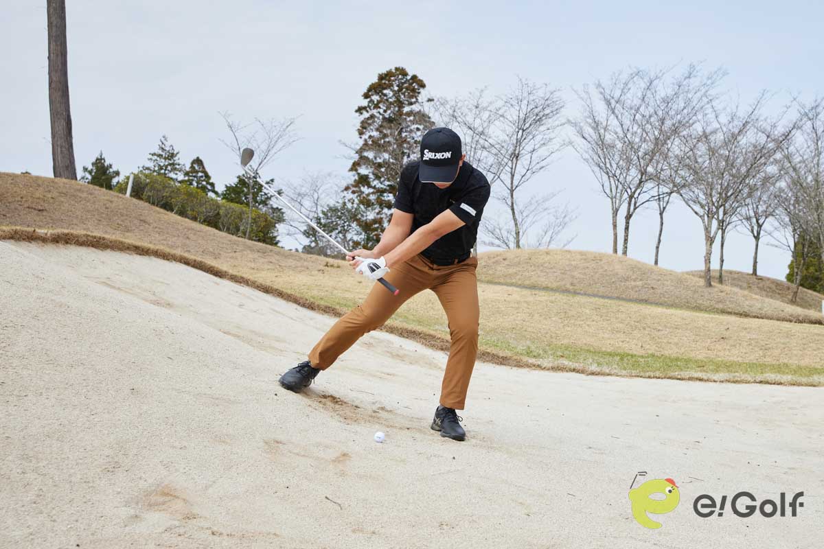 フェースを1時の向きに開き、真ん中よりもやや左足寄りにボールをセット。左足に重心を乗せてクローズスタンスで構えよう。右肩に担ぐようにバックスイングして、低いフォローを出せばOK。傾斜なりにヘッドが動き、フワっと球を上げることができる