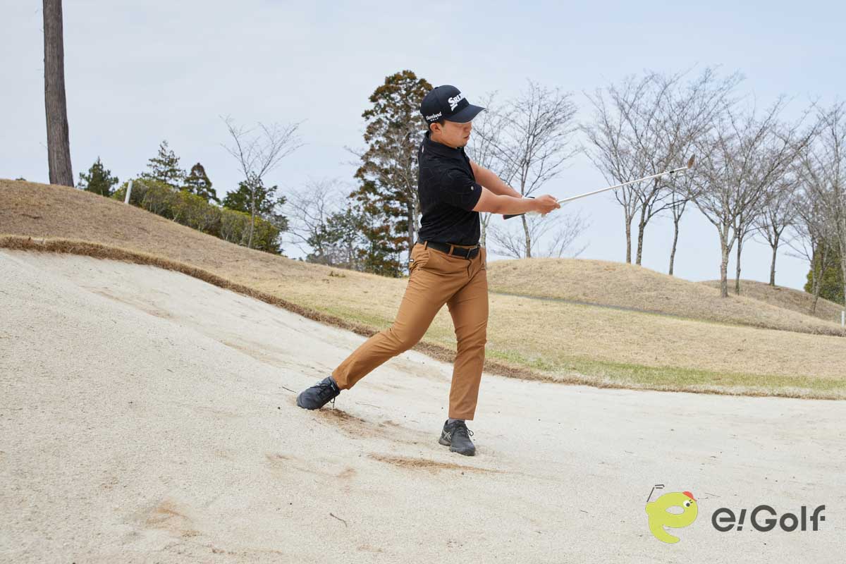 フェースを1時の向きに開き、真ん中よりもやや左足寄りにボールをセット。左足に重心を乗せてクローズスタンスで構えよう。右肩に担ぐようにバックスイングして、低いフォローを出せばOK。傾斜なりにヘッドが動き、フワっと球を上げることができる