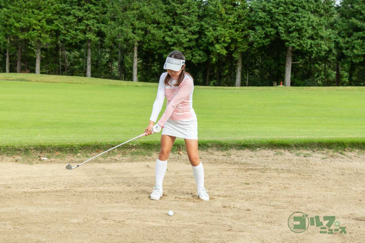 指一本ぶんクラブを短く握り、両足の真ん中より半個ぶん右にボールをセット。腕とクラブでL字を作るイメージでコックを入れて、腕と地面が水平になる位置までクラブを上げる。このセットアップと振り幅でフェアウェイバンカーの成功率はアップする