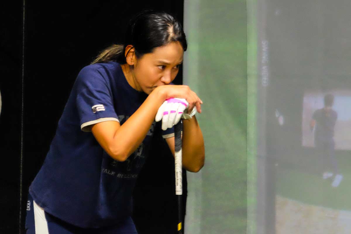 録画された自らのスイングを真剣な表情でチェック