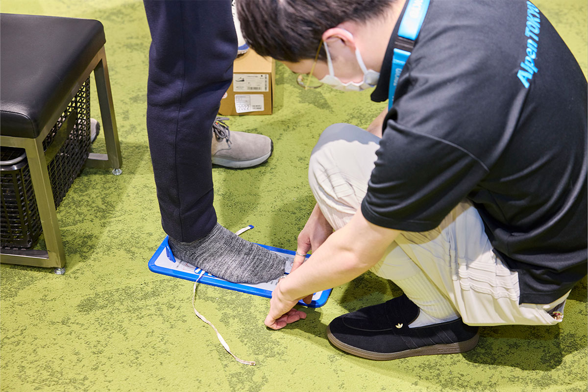 西村さんにフィッティングをしてもらう様子。数多くのゴルフシューズを試してきた鶴原さんも「BIOM C5」の履き心地を絶賛[写真：西村恵]