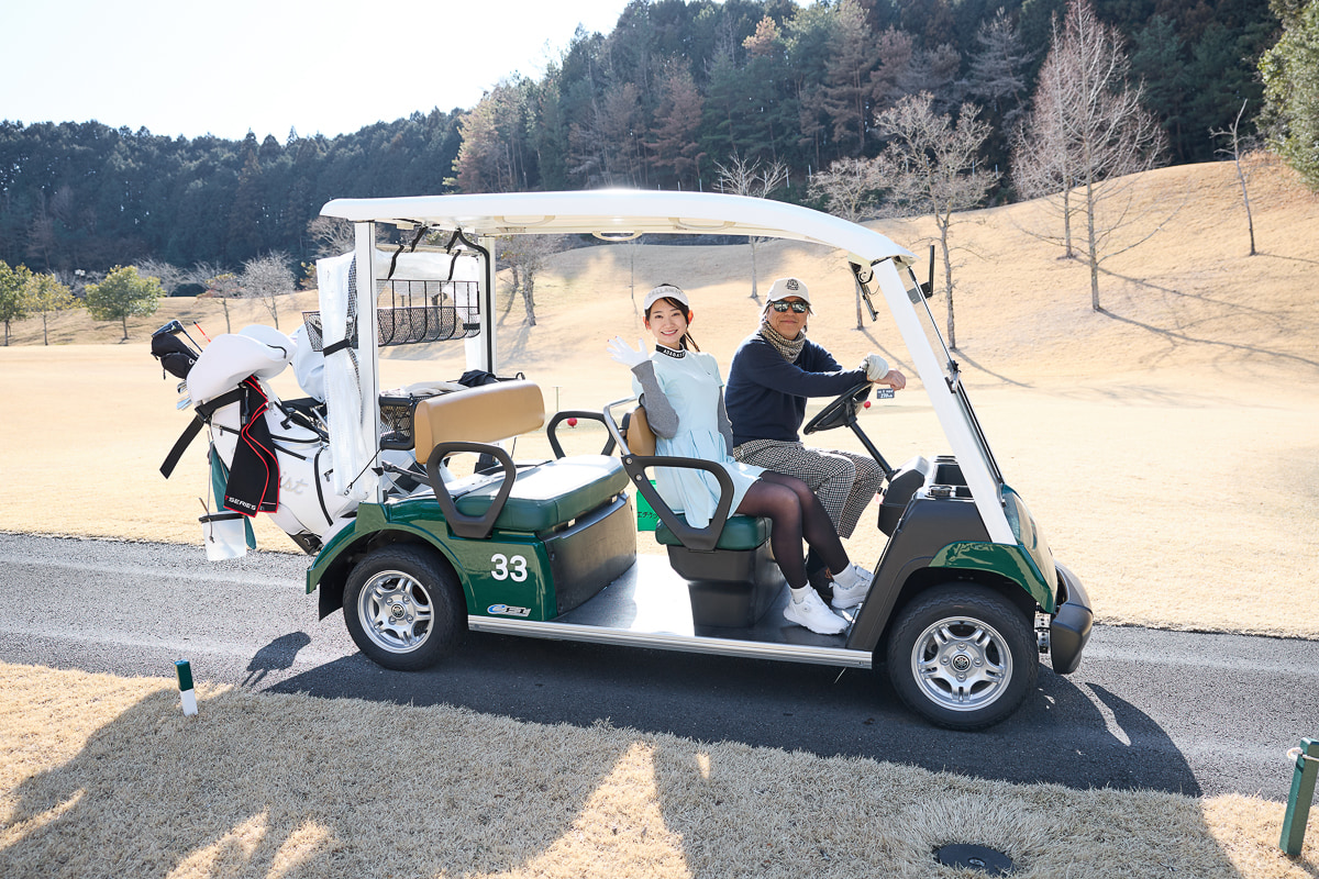ゴルフカートに乗って移動する2人[写真：望月浩彦]