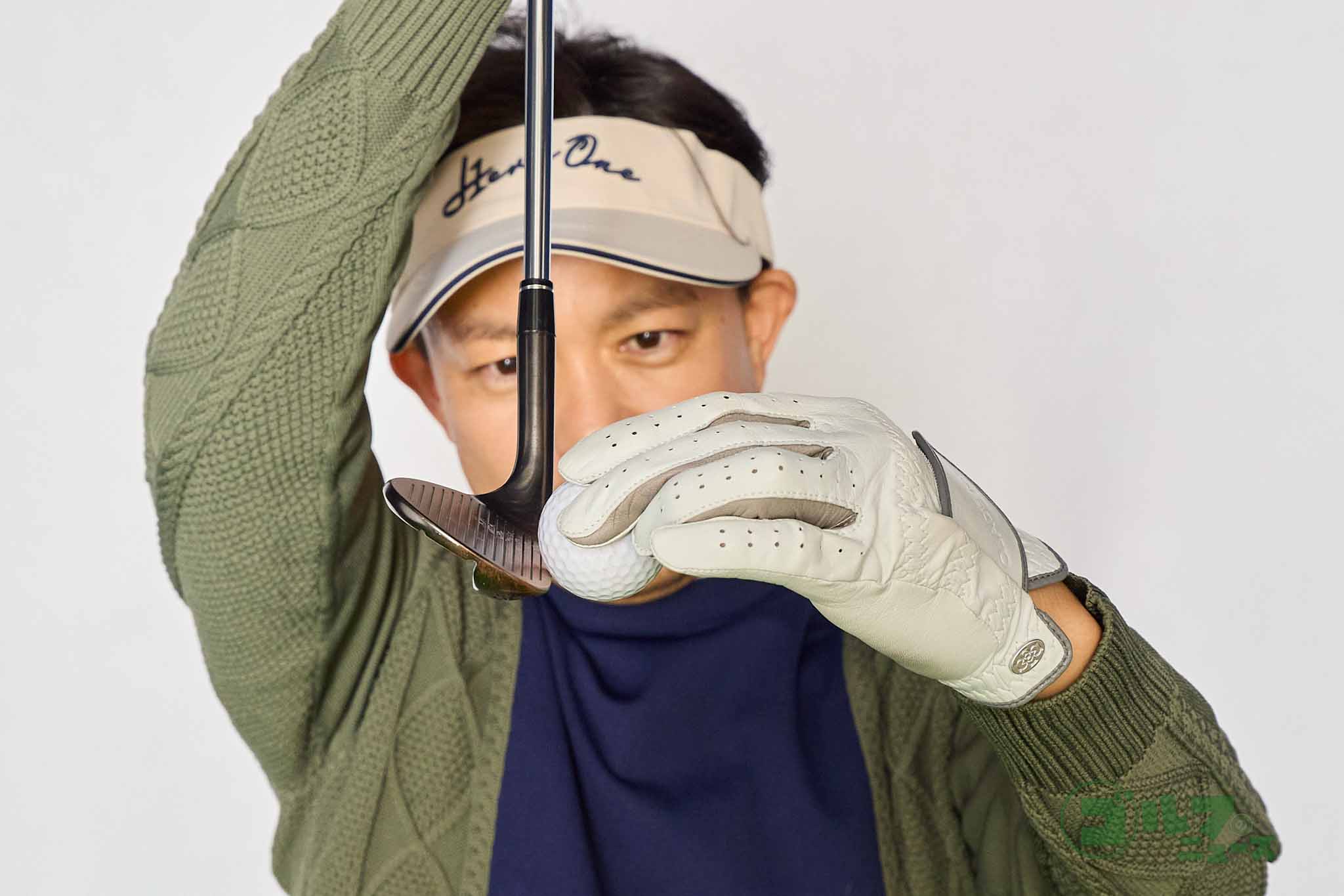 ボールの赤道と真下の南極部分の間にリーディングエッジを入れつつ、バンスをマットに当てないイメージでウェッジを打つ。このイメージでアイアンを打つとダフらなくなる　写真:西村恵