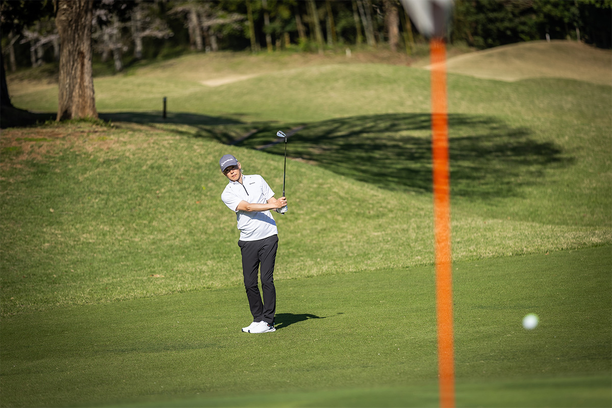 ピンまで30ヤードほどのアプローチショットを放つ鶴原さん。イメージ通りの出球で、スピン性能も申し分ないと語る。実際にスピンがしっかりとかかり、グリーン上でピタリと止まる弾道となっていた[写真：角田慎太郎]