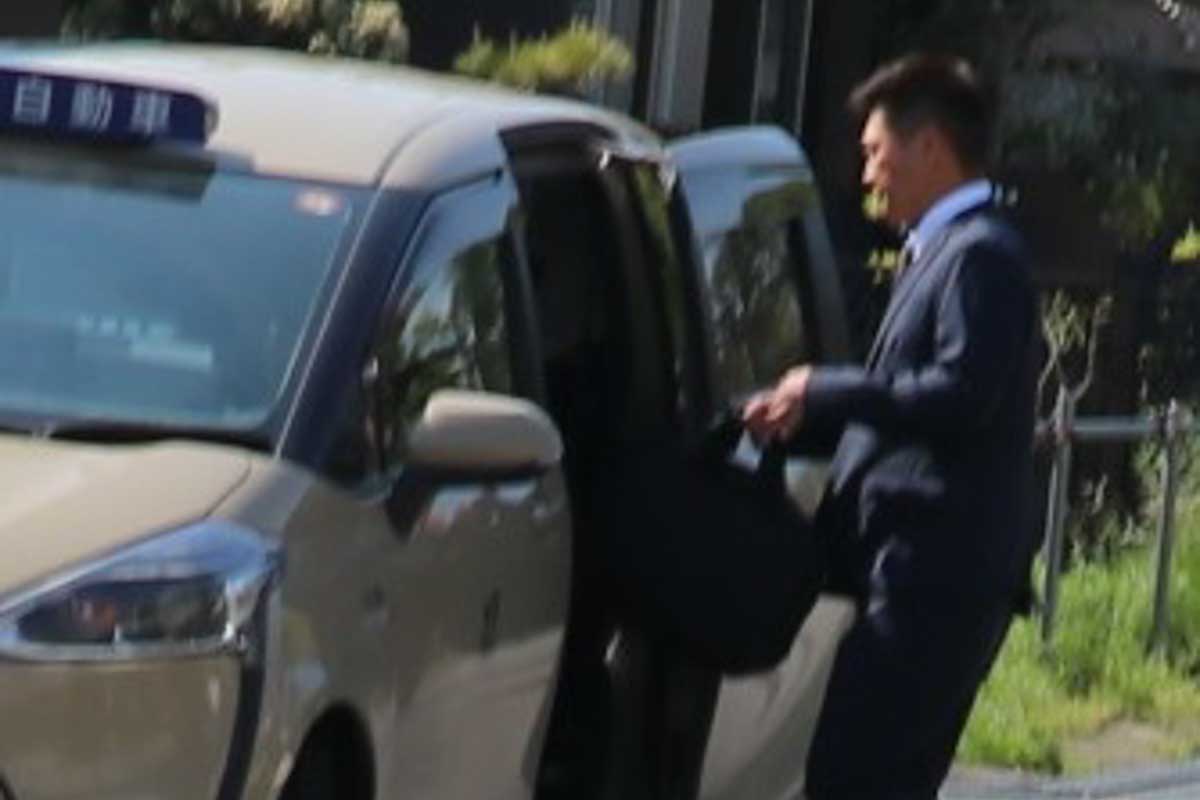 報道陣の質問には答えずタクシーで走り去った元ゴルフスタジアム代表の堀新氏　写真：清流舎